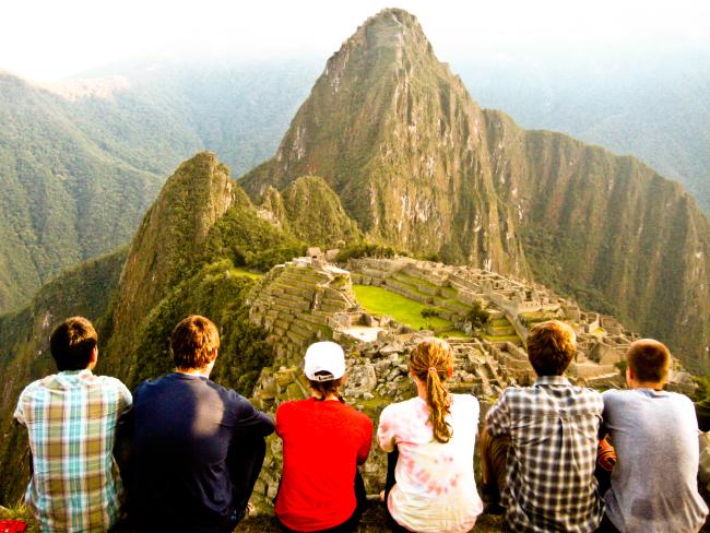 A group of students studying abroad and looking over a beautiful mountains