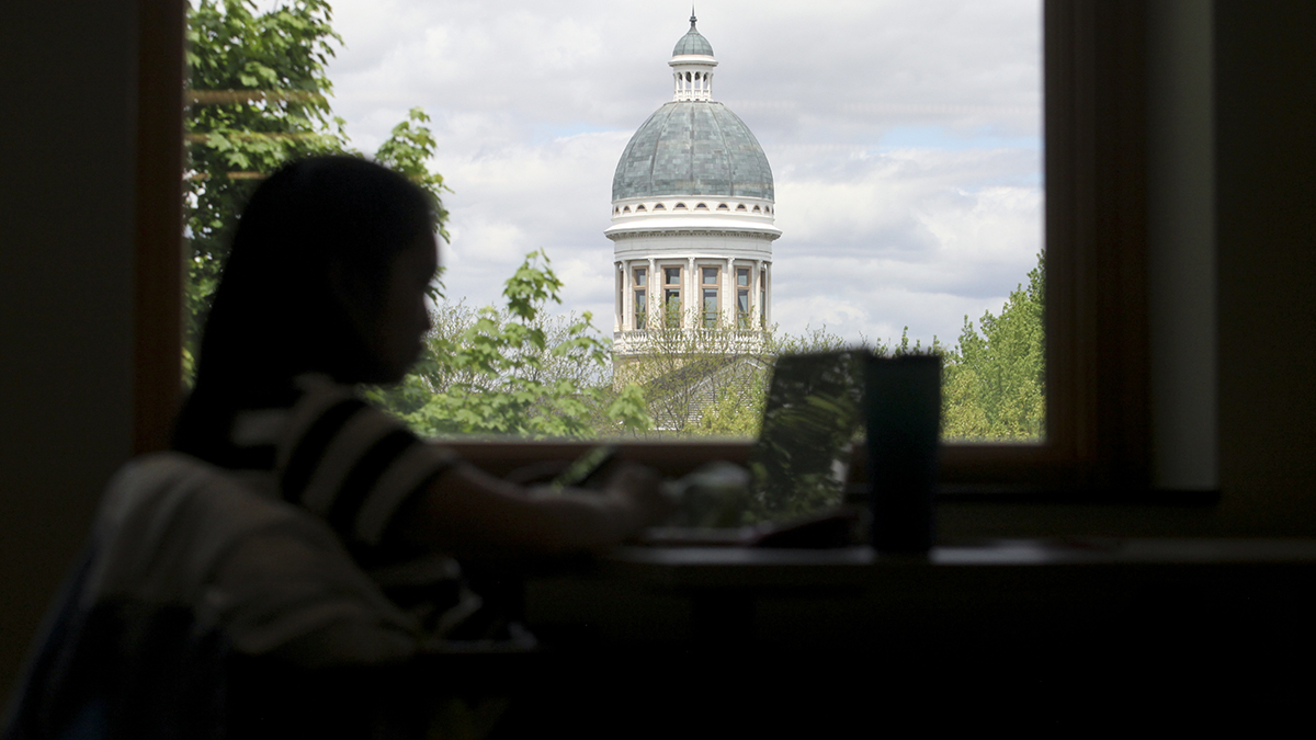 student studying in front of old main