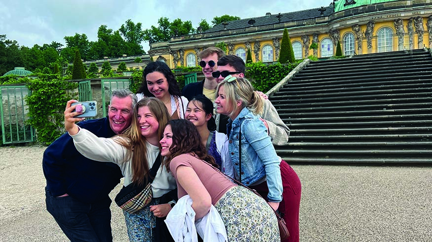 Augustana Choir Director Dr. Jon Hurty and students outside Sanssouci Palace in Potsdam, Germany.