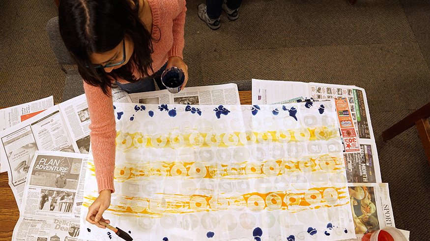 A student painting with a sponge brush