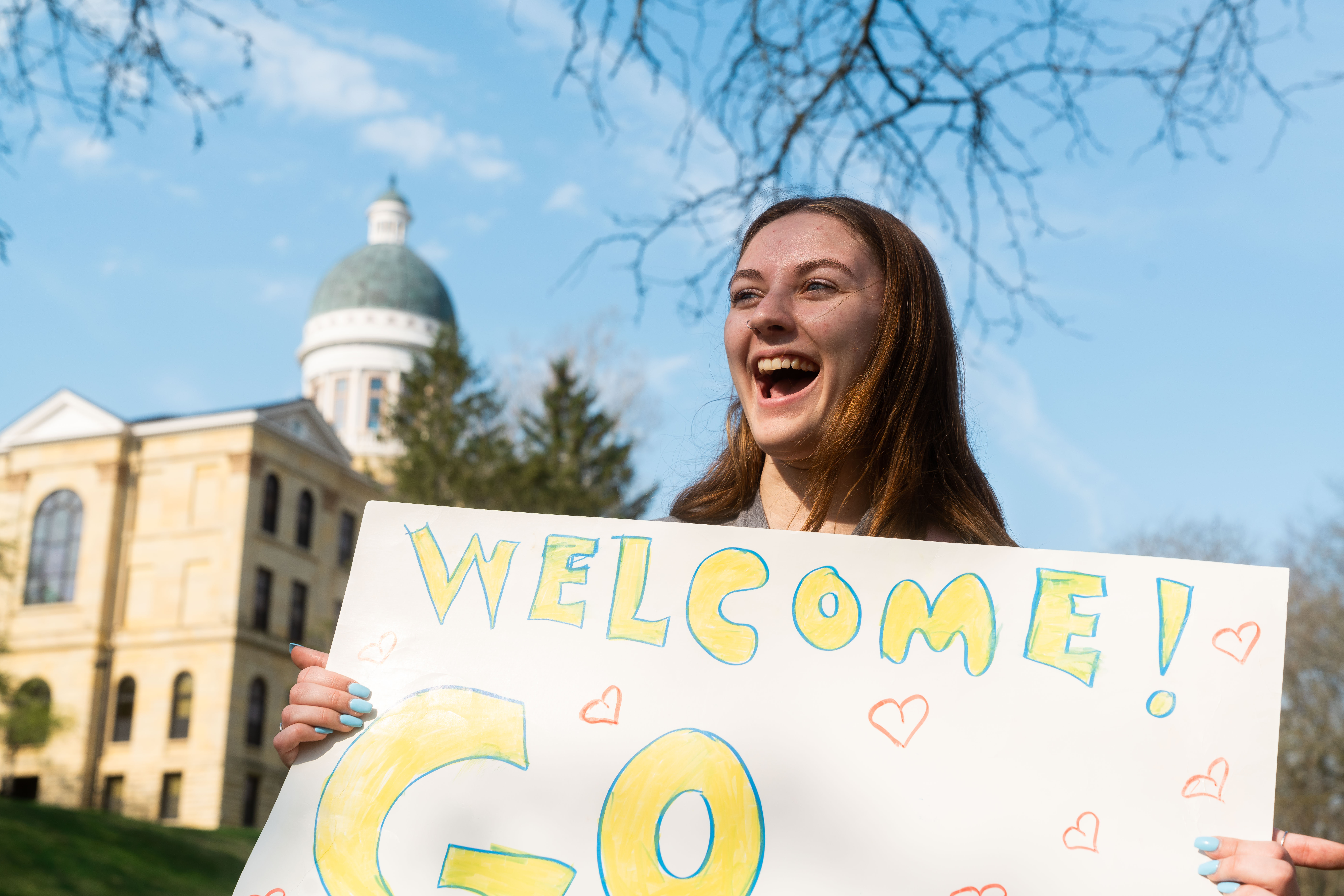 Student holding sign saying welcome.