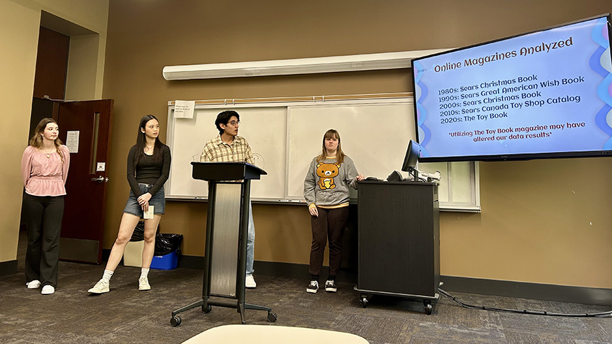 Four students presenting research