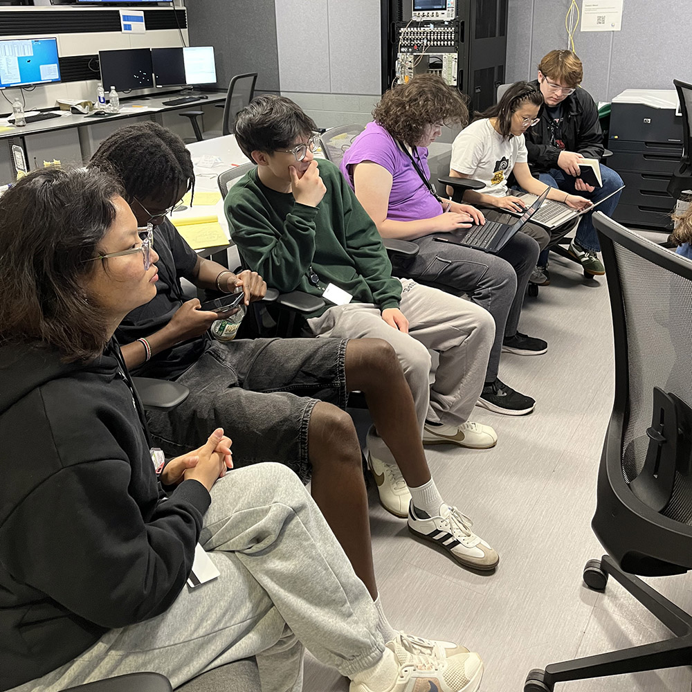Students sitting in chairs with laptops
