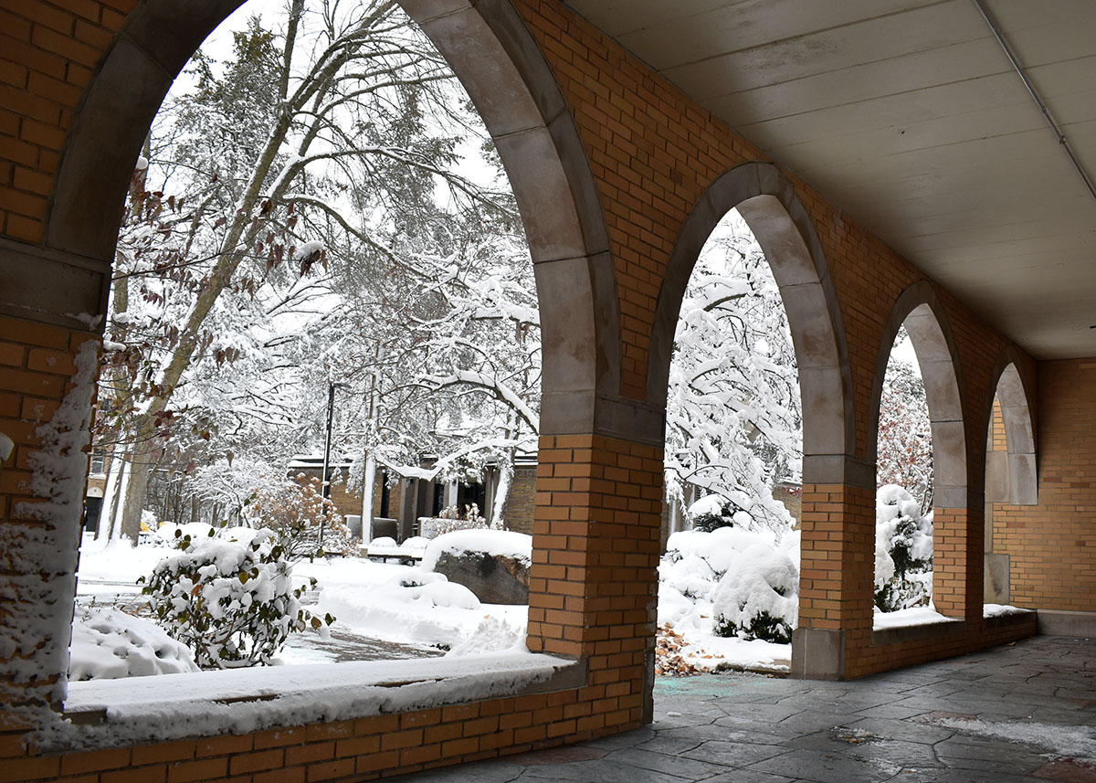 Brick Archway with Snow covered sidewalk and trees