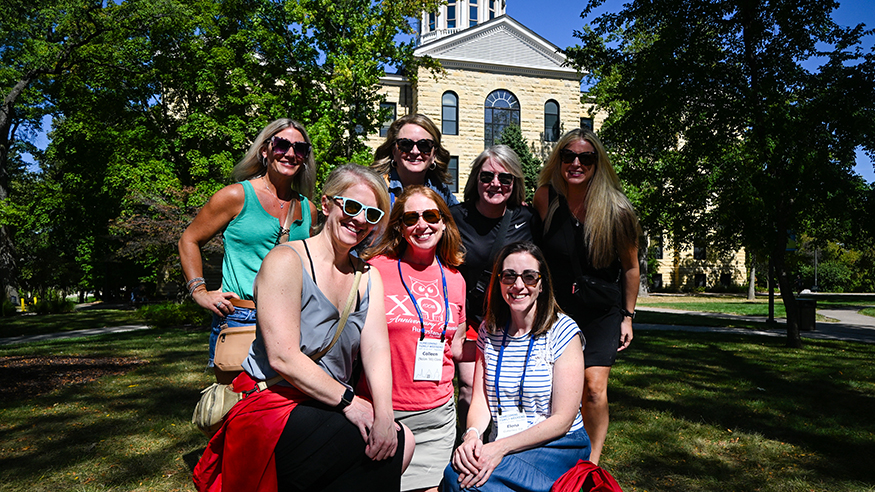 A group of friends pose in front of Old Main