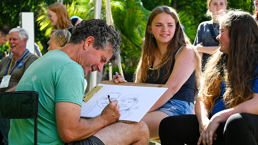 A caricature artist draws two young women