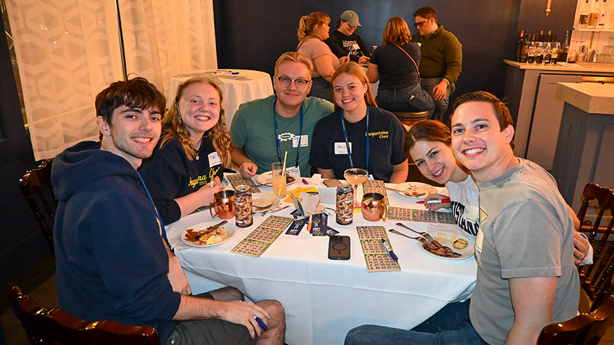 Friends pose at a table while playing bingo