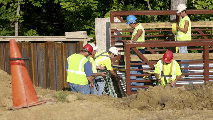 Crews work on the construction of the bridge that runs alongside the Slough Path.