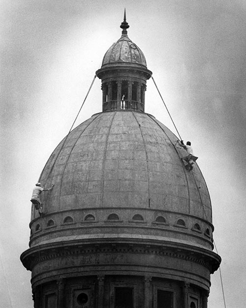 Two workmen on the dome of Old Main, date unknown