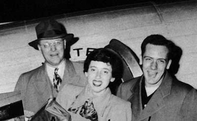 When Coach Martin Holcomb, D.A. Koch and Charlie Lindberg came home from the 1950 National Debate Tournament, they were greeted by "half the student body." Students hoisted the two debaters onto their shoulders and stuffed them into overloaded cars for the caravan back to campus.