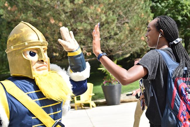 Gus gives a student a high-five. 