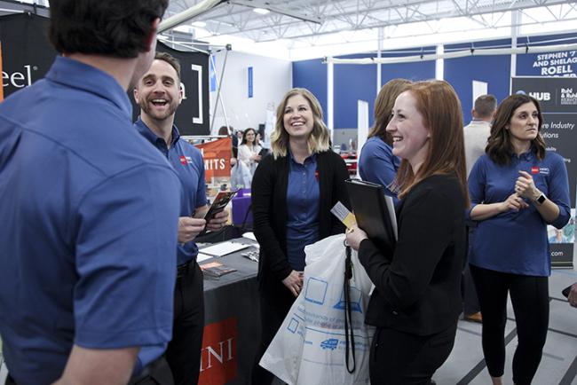 Students talk with employers at a career fair.