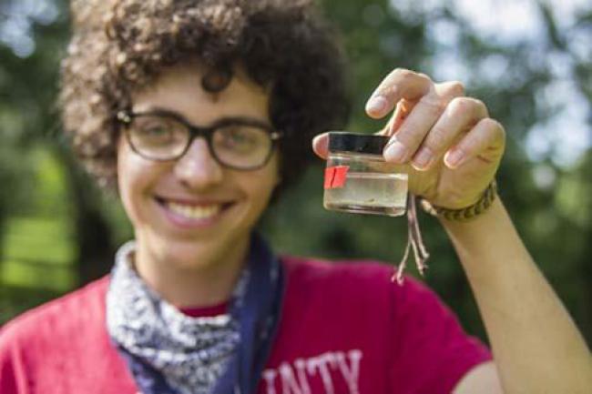 Student holding a jar with water to test