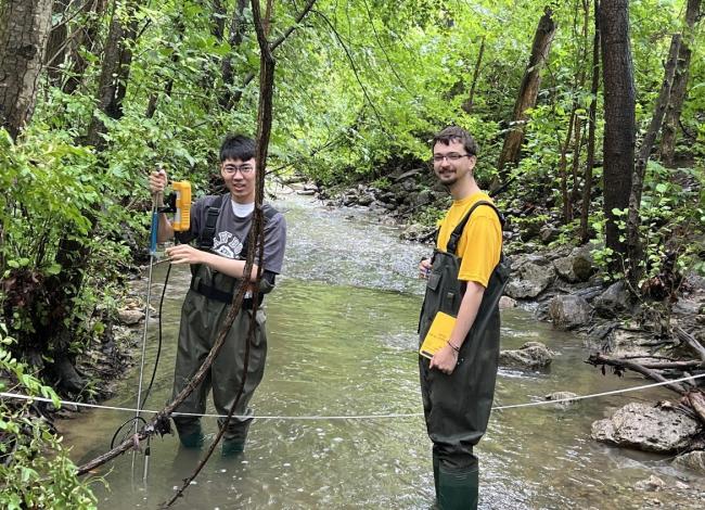Two students in water with instruments