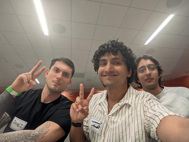 Three students smiling for a photo with peace signs