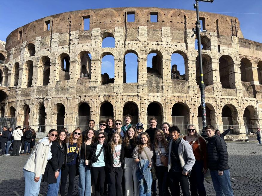 “Anatomy of Italy” class posing in front of a colosseum