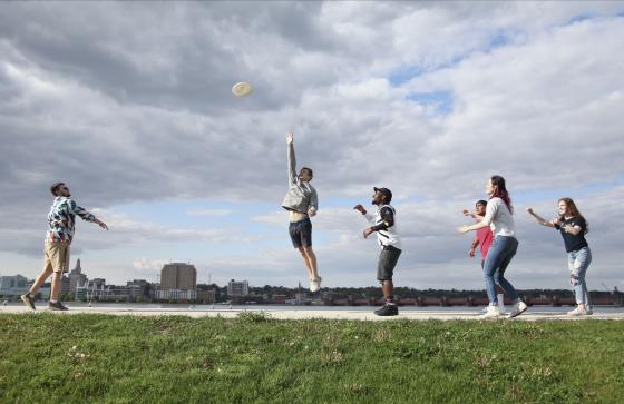students playing frisbee along the Mississippi river 